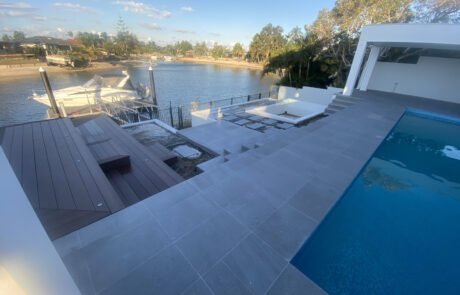 Outdoor patio, pool, and lower paved area tiling transformation in Mermaid Waters.