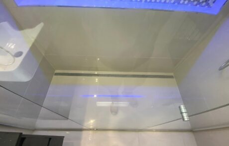 Biggera Waters finished shower base illuminated by blue LED lighting, showcasing a modern aesthetic.