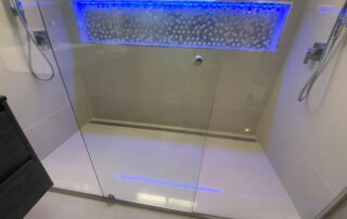 Complete Biggera Waters shower renovation glowing with blue LED lights, emphasizing luxury.