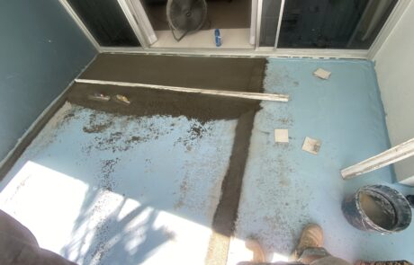 Process of applying screed on a balcony in Hope Island to ensure proper water runoff.
